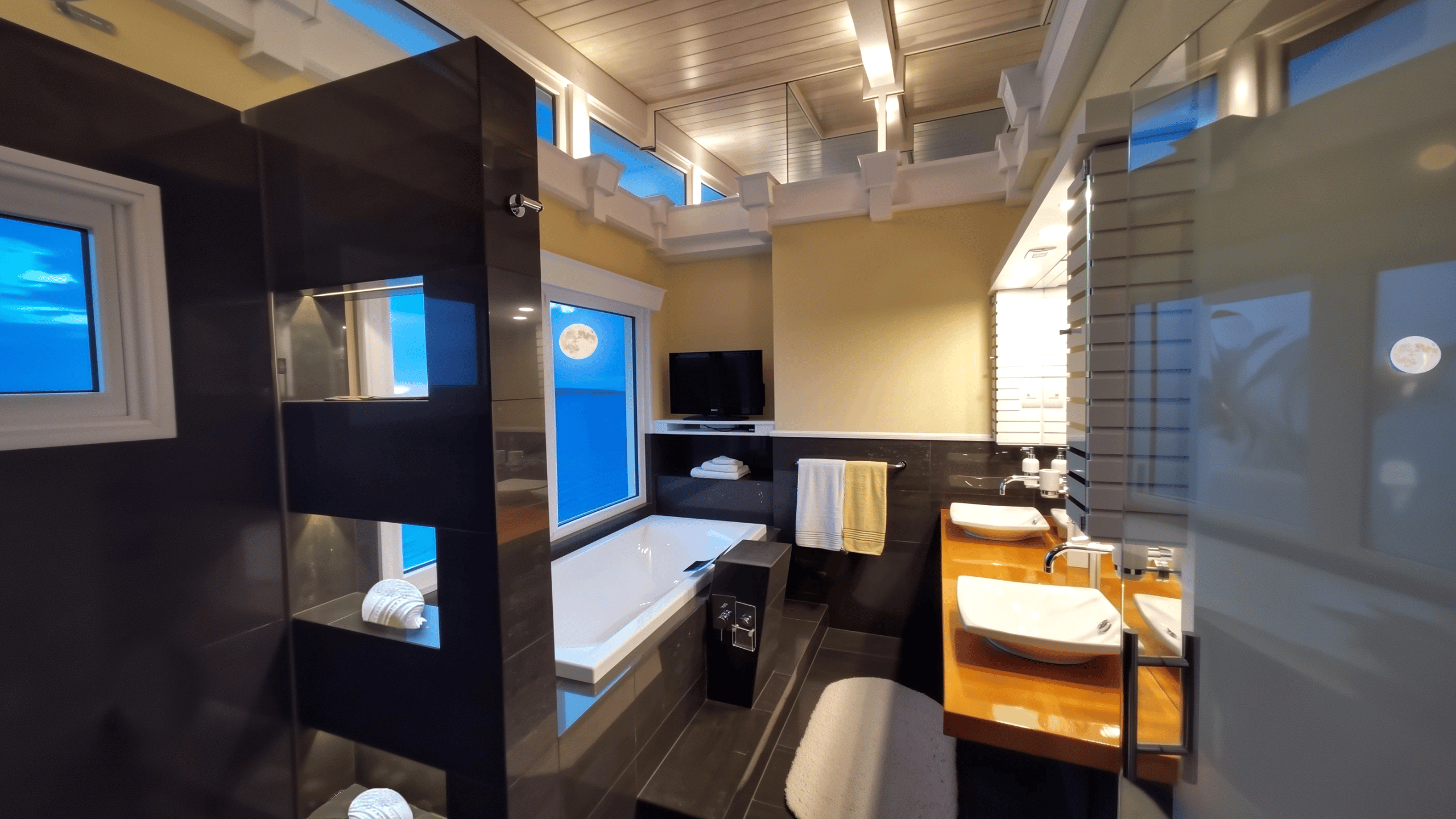 Ocean view bathroom in modern house for sale's Granny Flat ensuite, featuring bath, vanity, and shower.