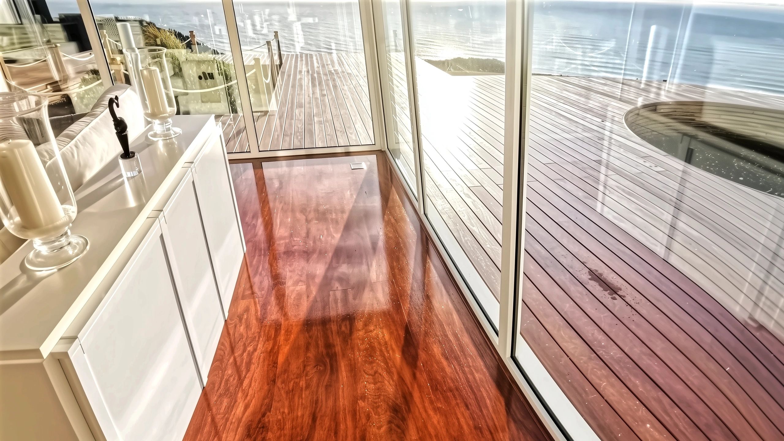 Glossy Tasmanian Oak wood flooring reflecting light in luxury beachfront property NZ living room.