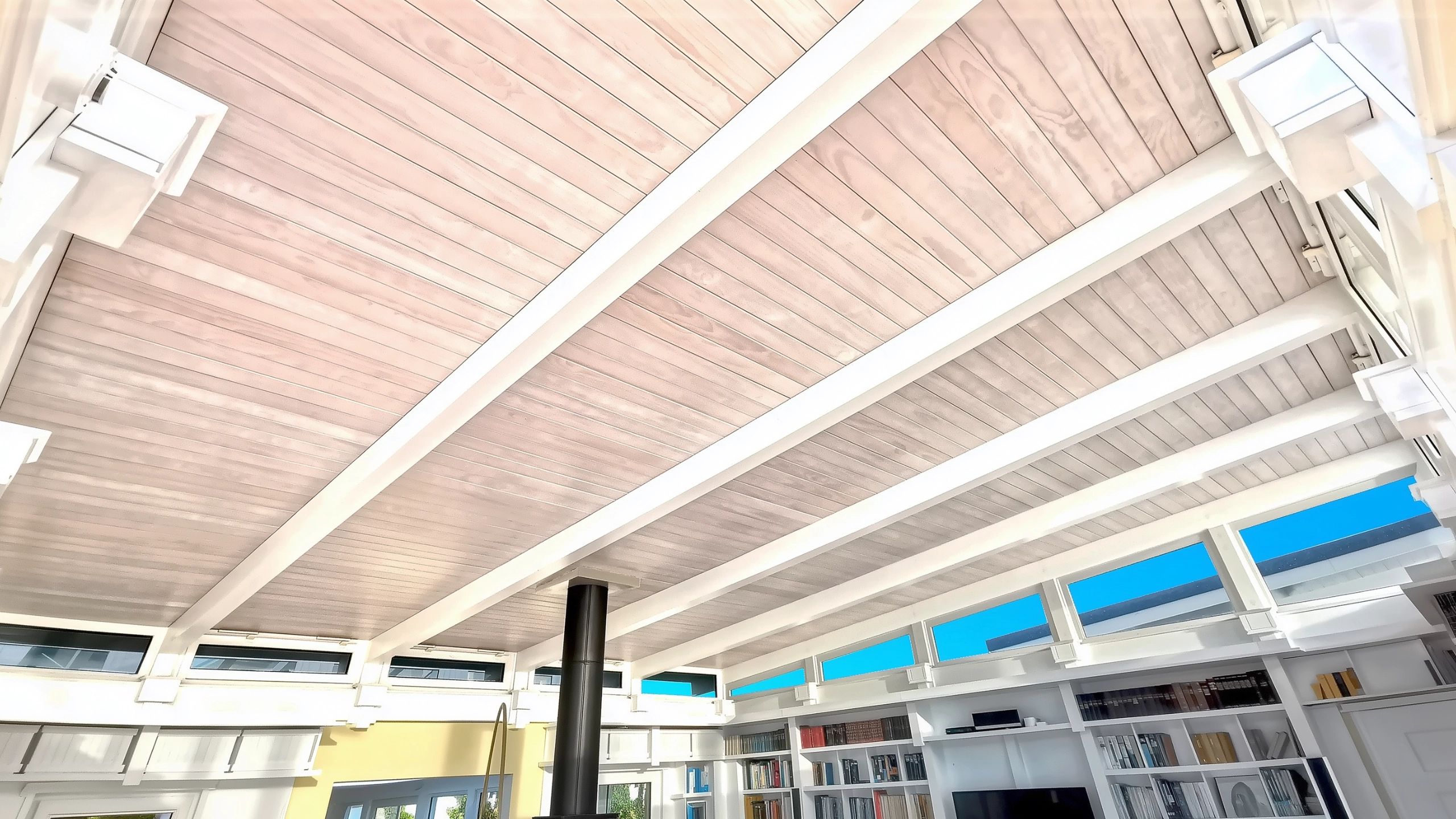Detailed view of white washed tongue and groove pine ceiling feature in water view home for sale.